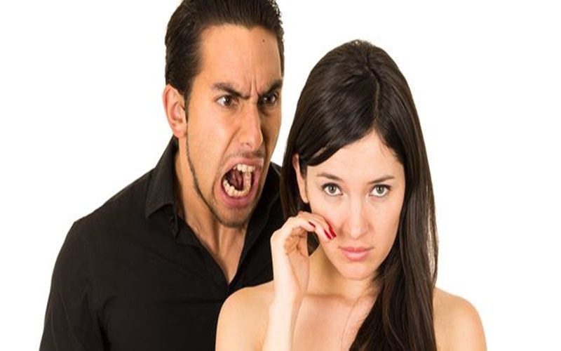 young beautiful woman crying while husband boyfriend screams at her isolated on white